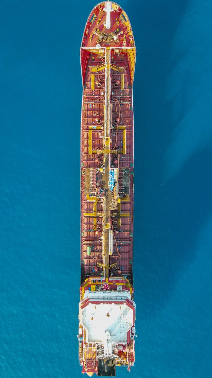 Top-down view of a cargo ship sailing in the clear blue waters near Kaş, Antalya, Türkiye.